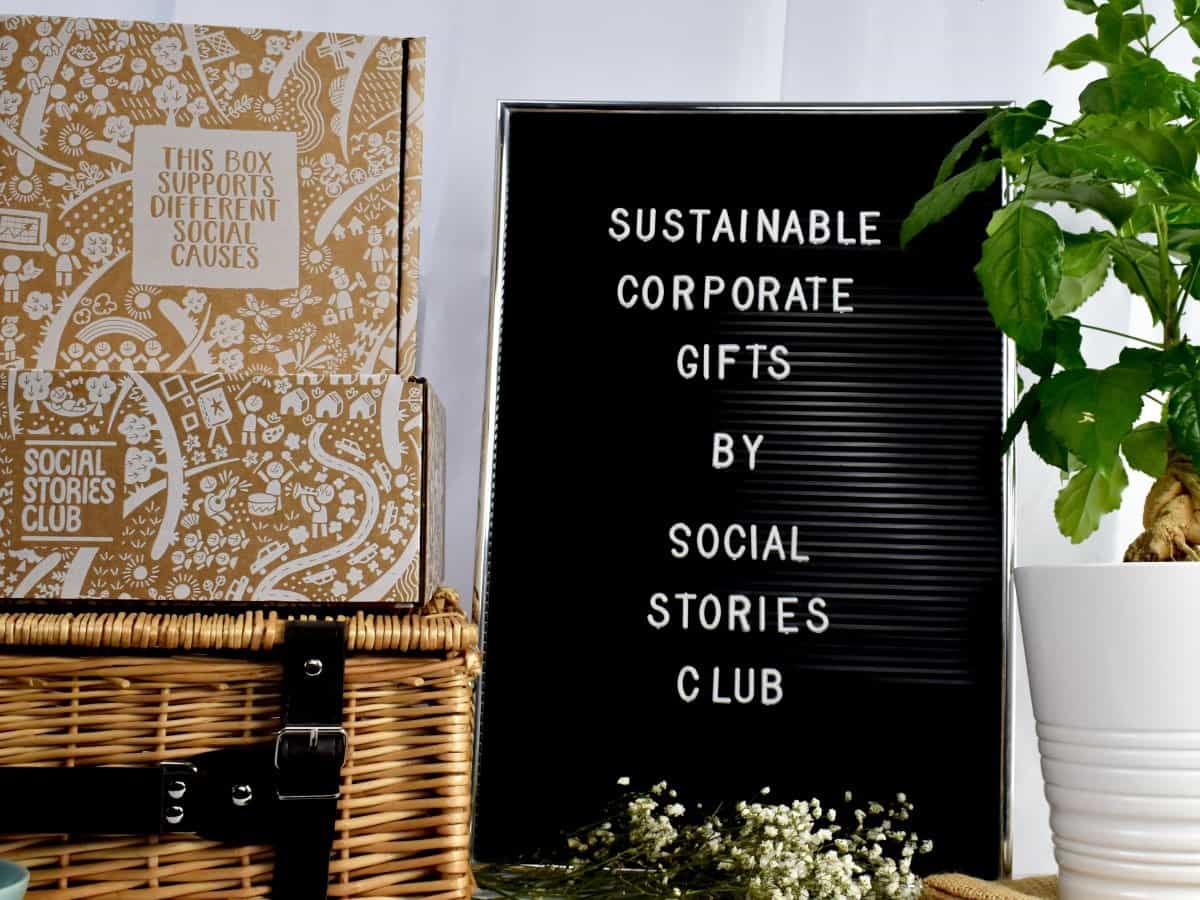 Sustainable gift boxes and hamper beside a Social Stories Club sign and a plant