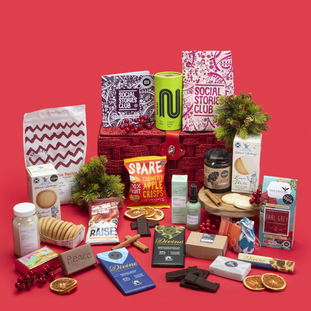 Family Gift Hamper open, brimming with Earl Grey and green teas, shortbread and lemon biscuits, selection of chocolates, apple crisps, maple pecans, honey, bath salts, shampoo bar, tote bag, brownie kit, hot chocolate melts, lotion, soap, story booklet, and personalised note in spacious sustainable packaging with festive family warmth.
