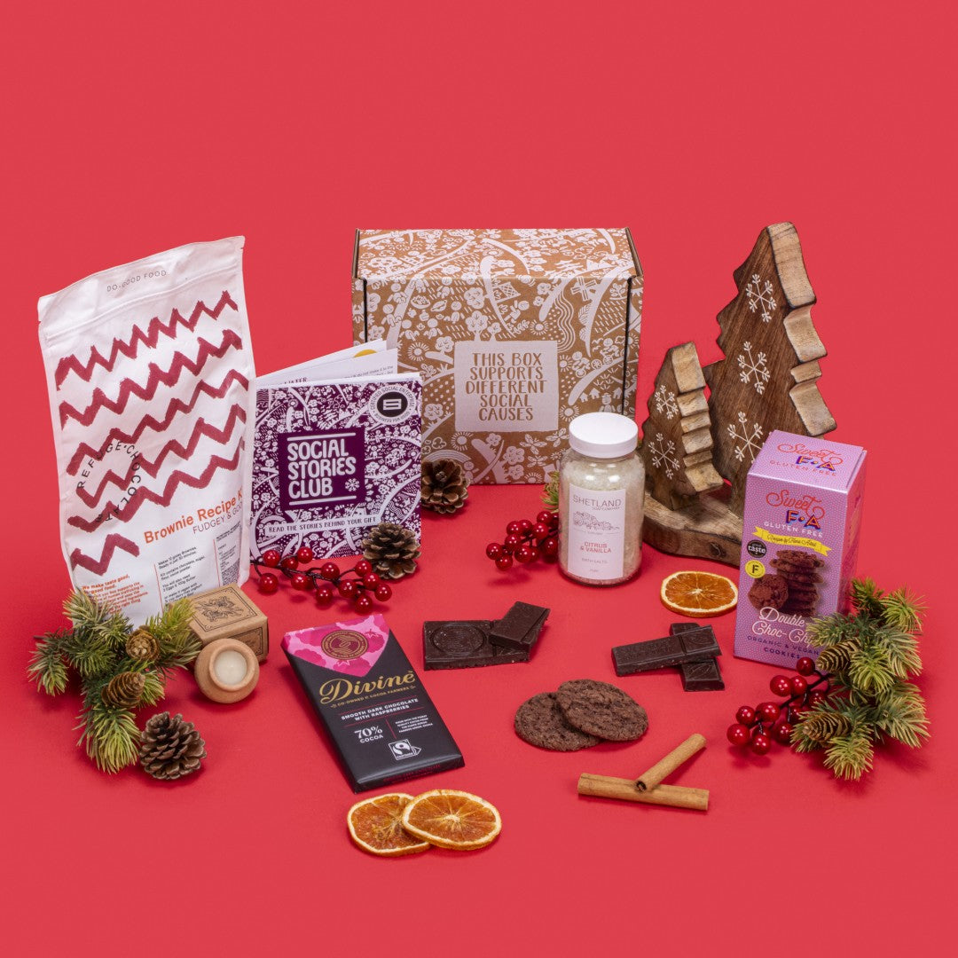 Gift Box for Couples open, revealing double chocolate chip cookies, raspberry dark chocolate, lavender candle, citrus vanilla bath salts, brownie kit, story booklet, and personalised note in intimate sustainable packaging with romantic festive touches.