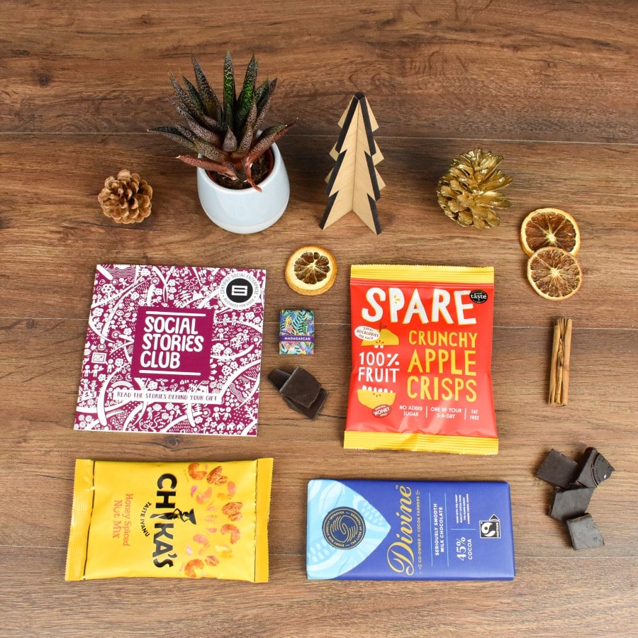 Secret Santa Letterbox open, displaying milk chocolate, dark napolitain, apple crisps, maple pecans, story booklet & personalised note in compact sustainable packaging with festive accents.