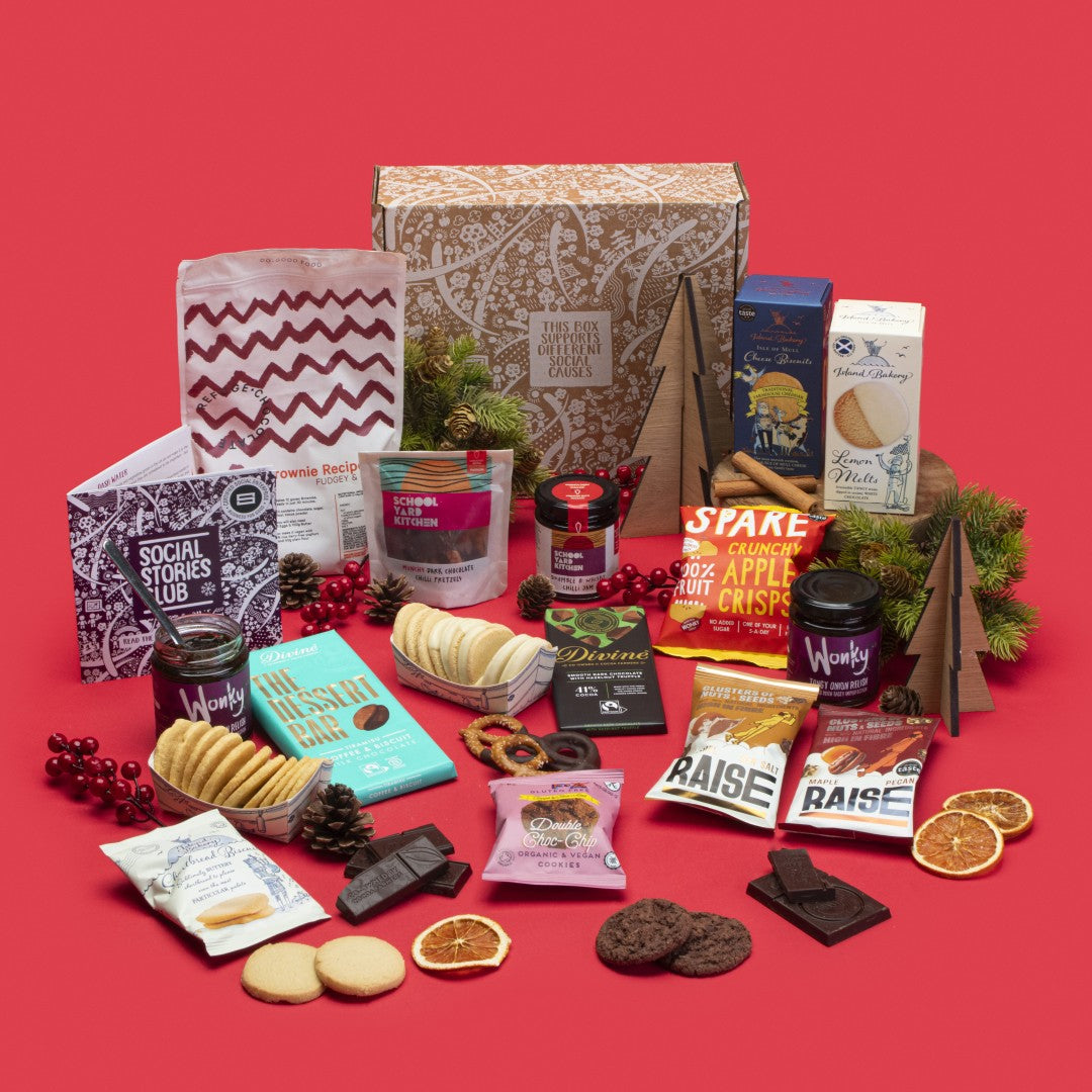 Shareable Feast Gift Box open, brimming with lemon melt biscuits, shortbread, chocolate chip cookies, cheese biscuits, tiramisu and hazelnut truffle chocolates, apple crisps, tomato and onion relishes, chilli pretzels, chilli jam, maple pecan and salted caramel nuts, brownie kit, story booklet, and personalised note in eco-friendly packaging with festive touches.