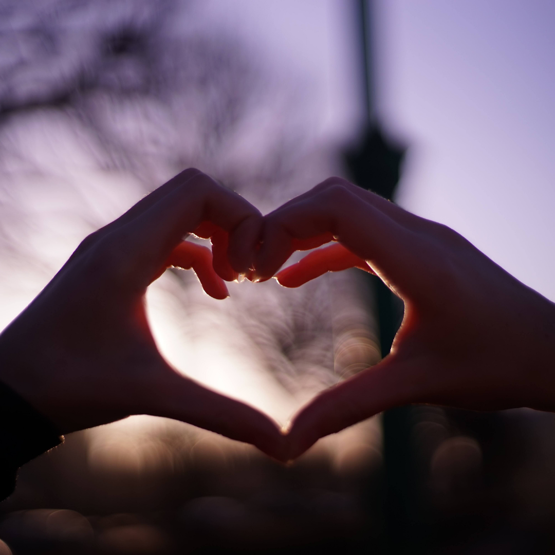 hands placed together to make a love heart shape