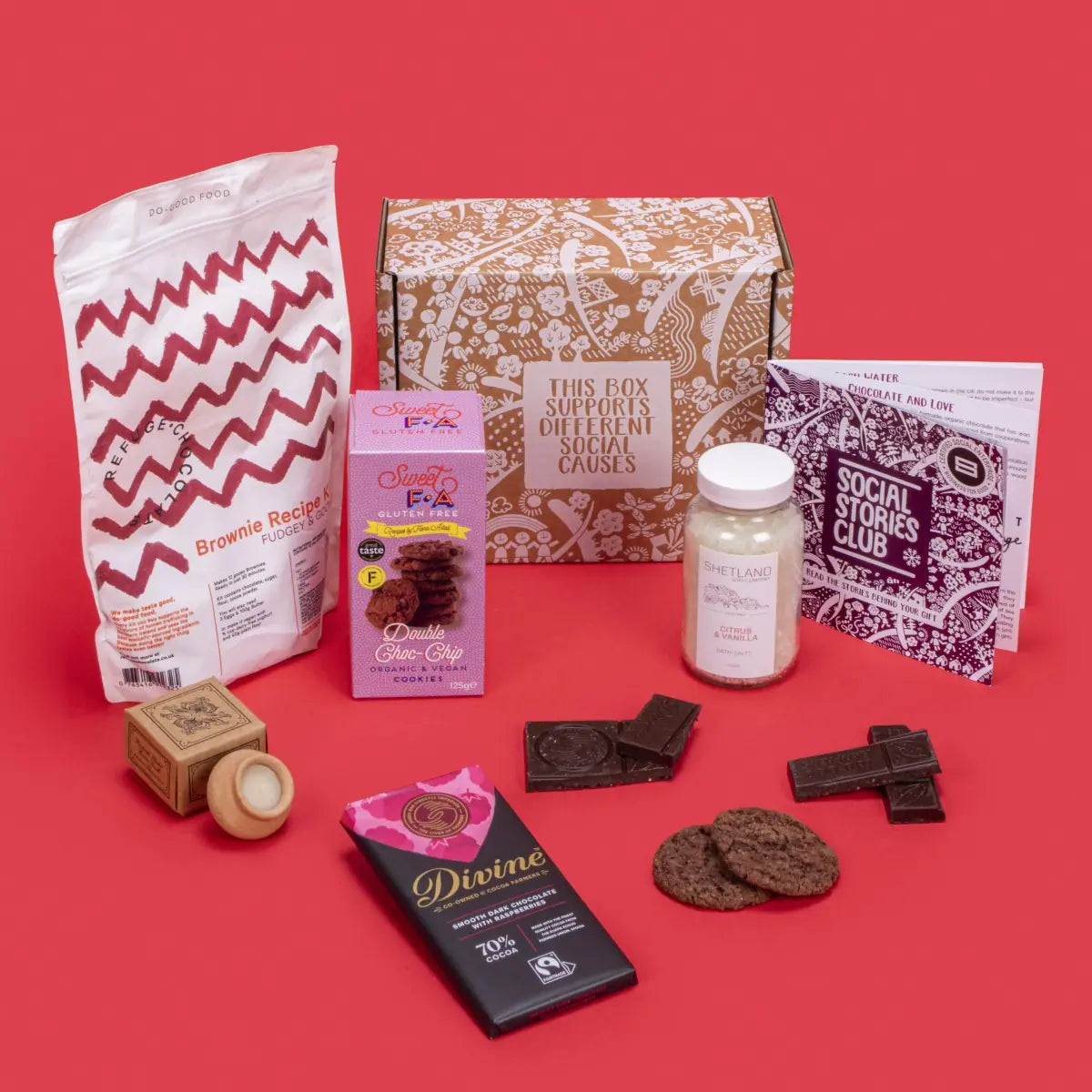 Gift Box for Couples open, revealing double chocolate chip cookies, raspberry dark chocolate, lavender candle, citrus vanilla bath salts, brownie kit, story booklet, and personalised note in intimate sustainable packaging with romantic festive touches.