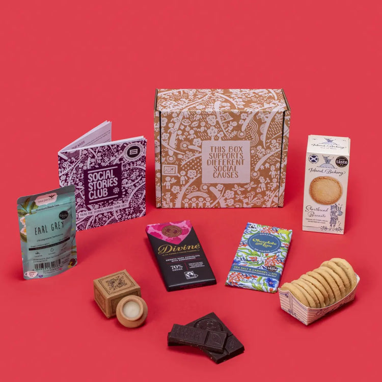 Hug In A Box open, displaying twin-pack Earl Grey tea, shortbread biscuits, sea salt caramel chocolate, raspberry dark chocolate, lavender candle, story booklet & personalised note in comforting sustainable packaging with festive accents.
