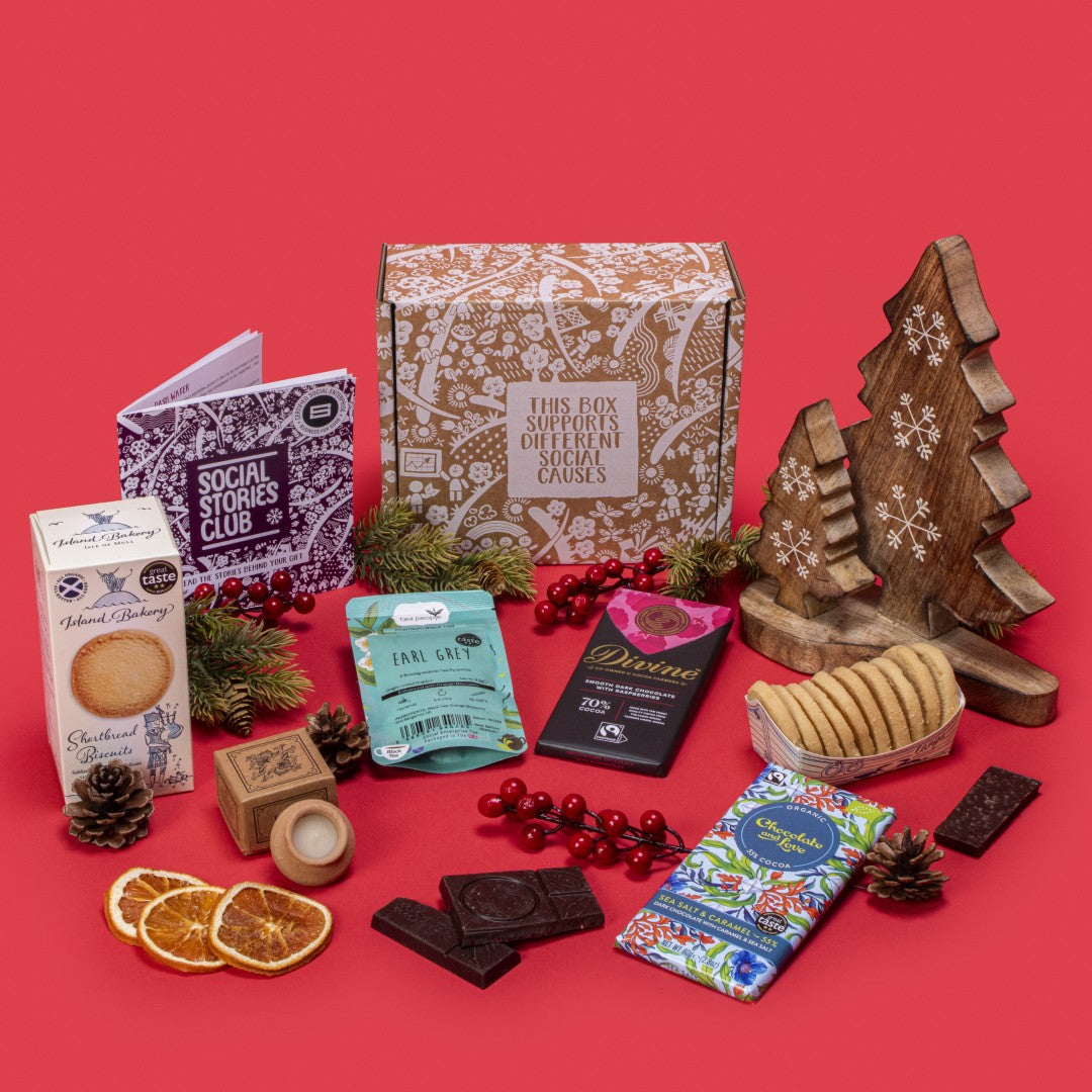 Hug In A Box open, displaying twin-pack Earl Grey tea, shortbread biscuits, sea salt caramel chocolate, raspberry dark chocolate, lavender candle, story booklet & personalised note in comforting sustainable packaging with festive accents.