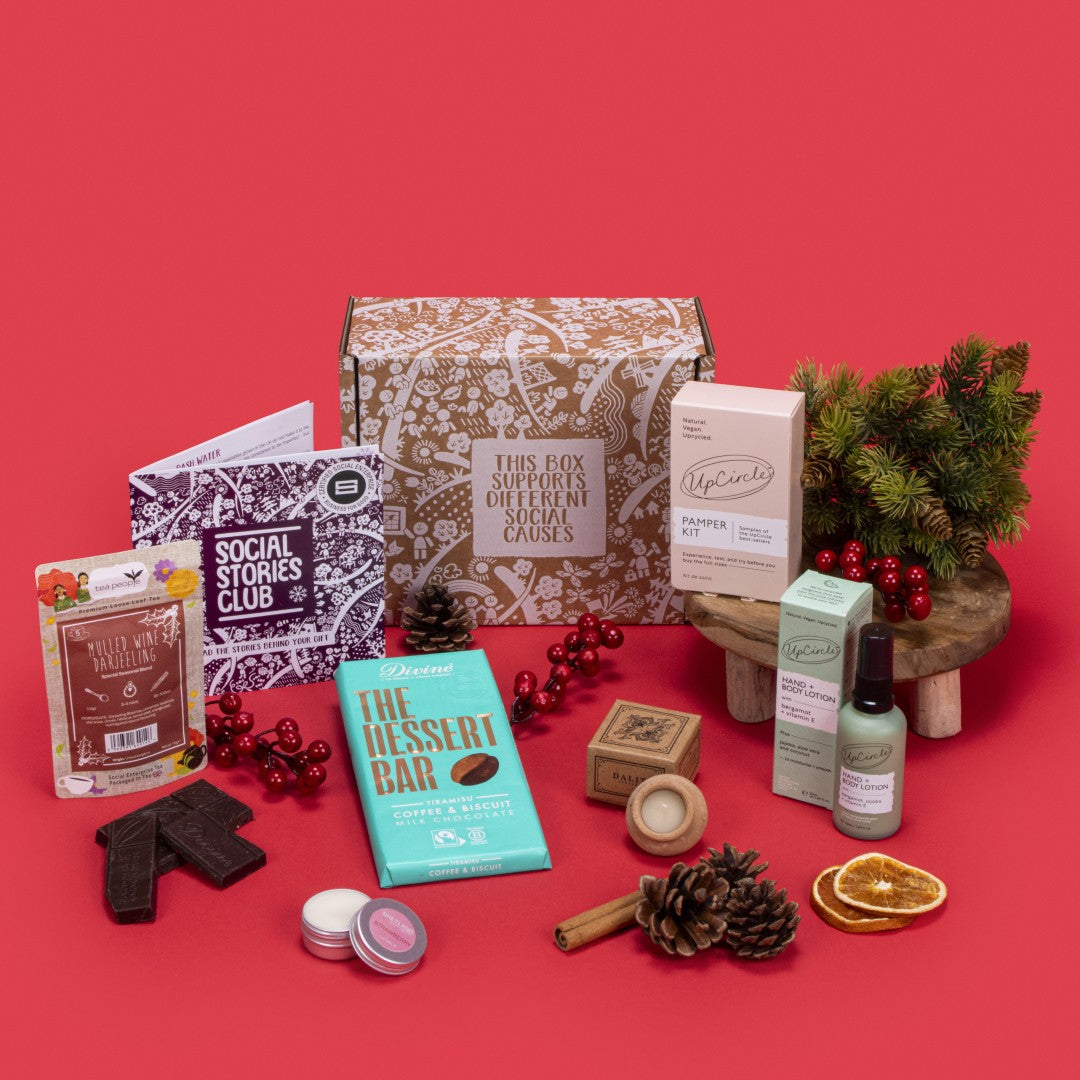 Luxury Self Care Gift Box open, revealing mulled wine tea, tiramisu chocolate, lavender candle, strawberry lip balm, pamper kit, bergamot lotion, story booklet, and personalised note in opulent sustainable packaging with serene festive accents.