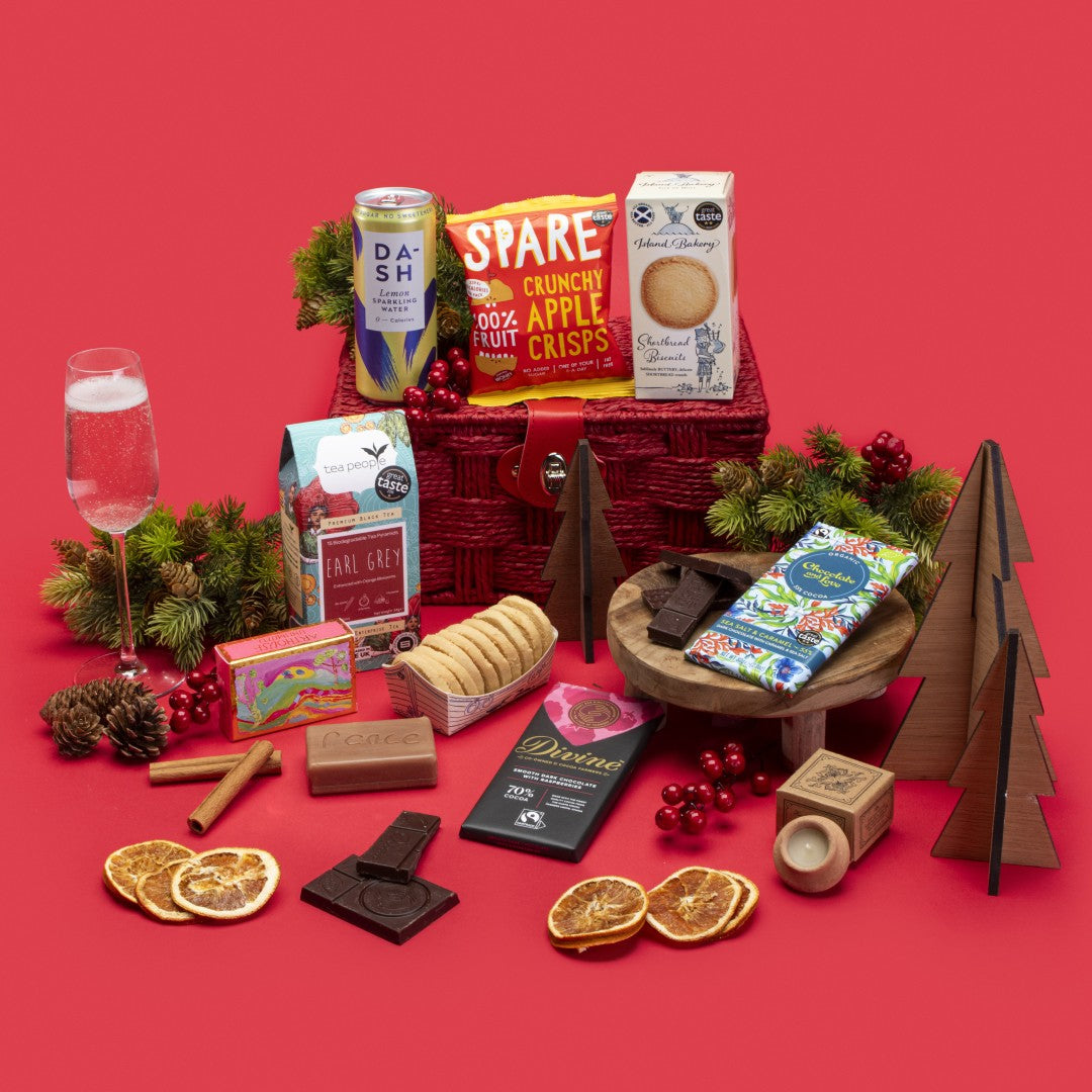 Original Social Stories Gift Hamper open, showcasing Earl Grey tea, shortbread biscuits, sea salt caramel chocolate, raspberry dark chocolate, lavender candle, apple crisps, lemon sparkling water, rosemary orange soap, story booklet & personalised note in luxurious sustainable packaging with festive accents.