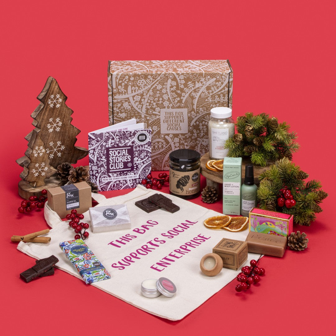 Pamper Hamper Gift Box open, revealing sea salt caramel chocolate, lavender candle, honey, citrus vanilla bath salts, strawberry lip balm, shampoo bar, cotton tote bag, bergamot lotion, rosemary orange soap, story booklet, and personalised note in serene sustainable packaging with festive and celebratory accents.