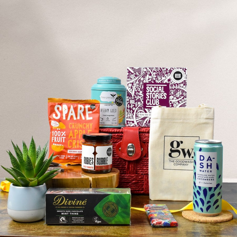 Vegan Treats Gift Hamper - This is an image of a plant based gift. In this image is a sustainable gift hamper which is surrounded by social enterprise vegan products with social stories.