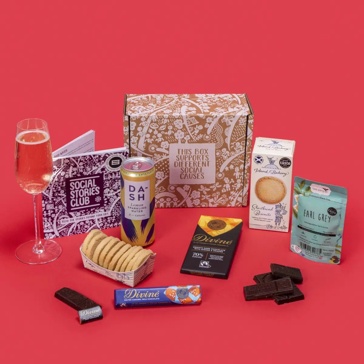 Conscious Collection gift box with chocolate, shortbread, Earl Grey tea and sparkling water, beside its story booklet