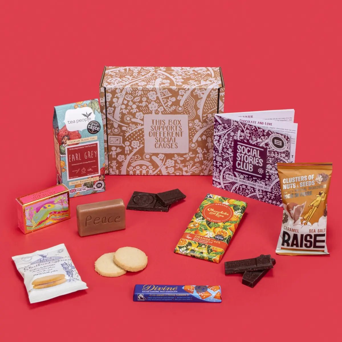 Happy Birthday Gift Box with Earl Grey tea, chocolate, shortbread, nuts and seeds, and soap, beside its box and booklet