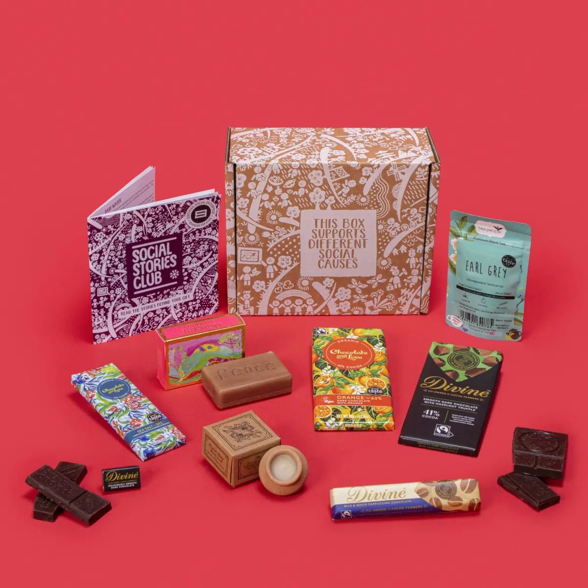 Pick Me Up Gift Box with Earl Grey tea, chocolate bars, a lavender candle and soap, beside its gift box and story booklet