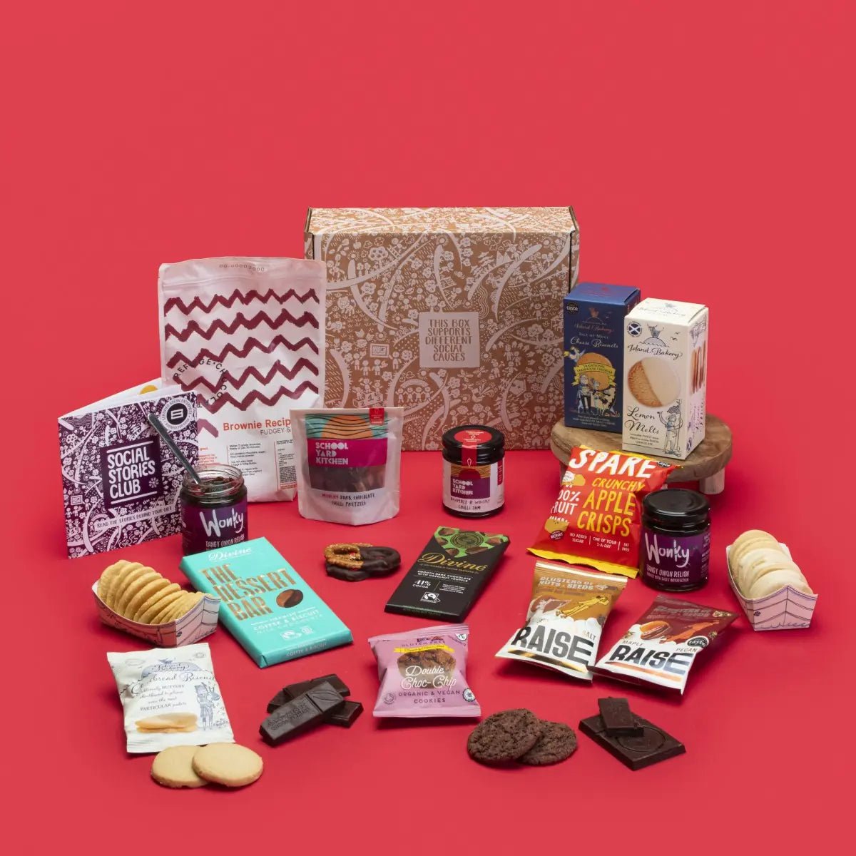 Shareable Feast Gift Box with relishes, cheese biscuits, crisps, cookies, a brownie kit and chocolate, beside its gift box